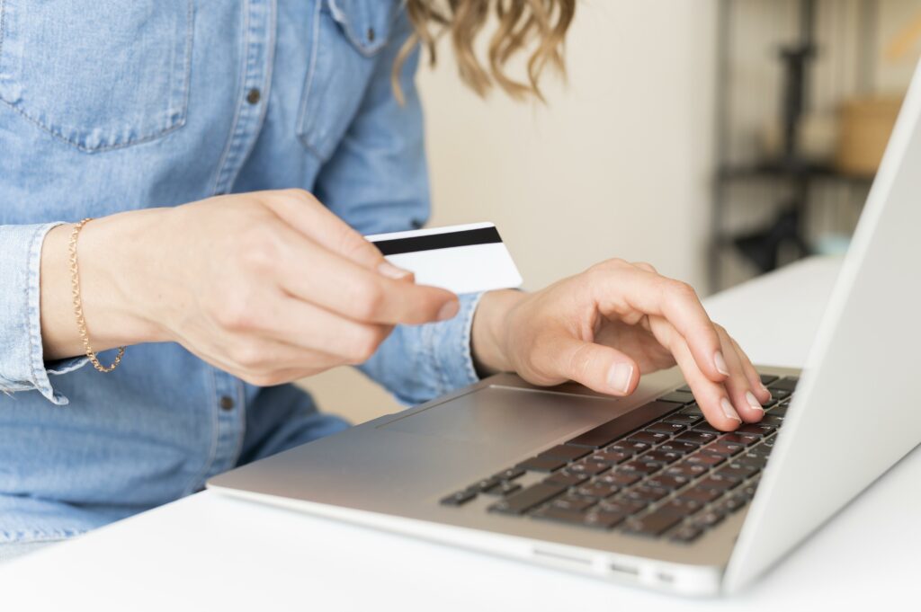 Persona con una tarjeta de crédito y una laptop